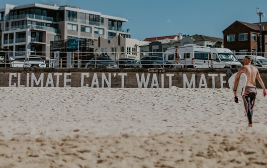 Climate Cant wait mate sign on beach
